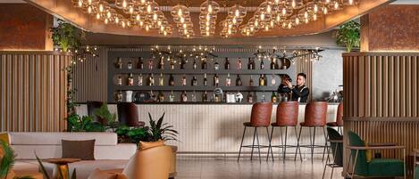 A modern bar area with a bar counter, multiple stools, and a variety of bottles.