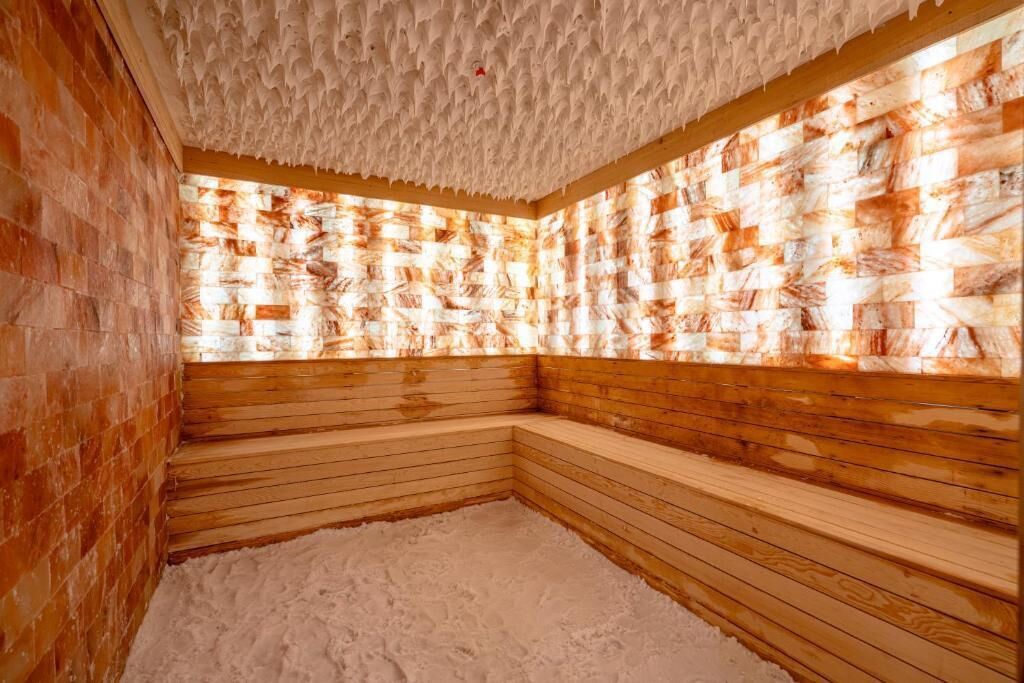 A sauna room with wooden benches and a textured ceiling.