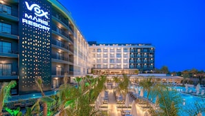 A resort with a pool area, outdoor seating, and a building with a large sign. - Vox Maris Resort- Ultra All Inclusive (Manavgat)