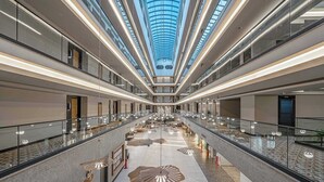 A spacious atrium with a high ceiling, glass railings, and a central open area with seating and decorative elements. - Vox Maris Resort- Ultra All Inclusive (Manavgat)