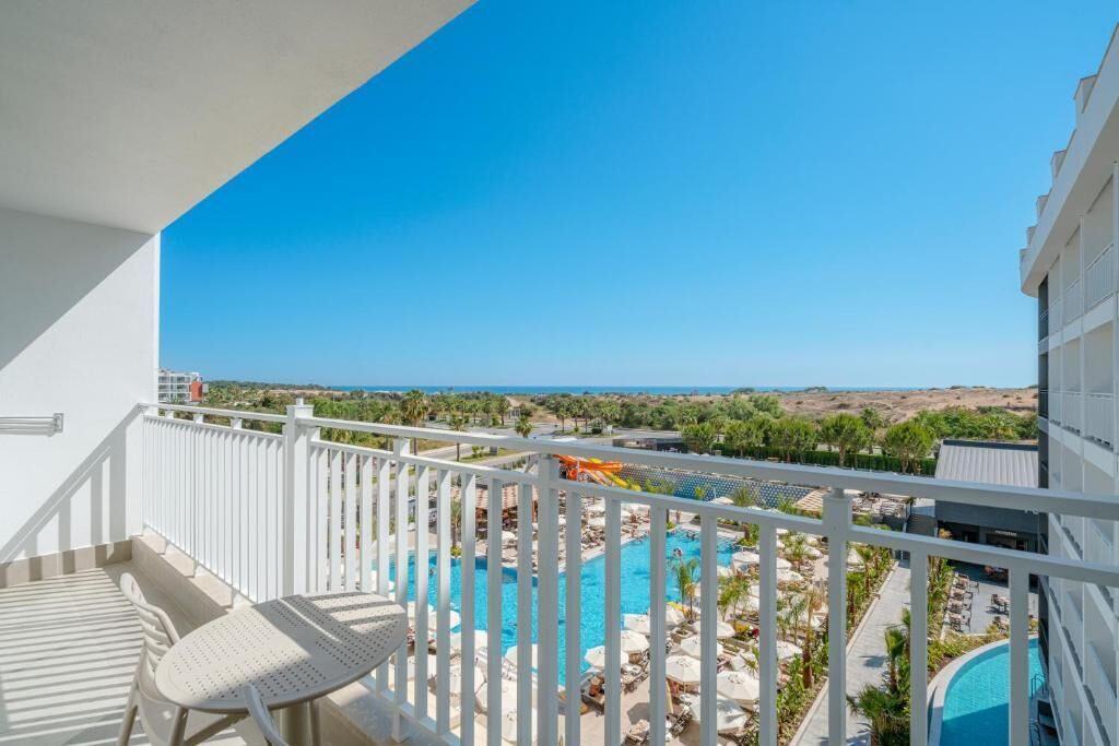 En balkon med udsigt over en swimmingpool og et ørkenlandskab.