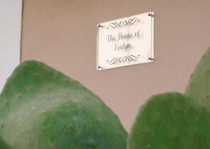 Un letrero en una pared color crema que dice 'The House of Evelyn'.