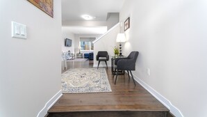 A modern living room with a staircase, a dining area, and a kitchen in the background. - TownHome In Ottawa! (Ottawa)