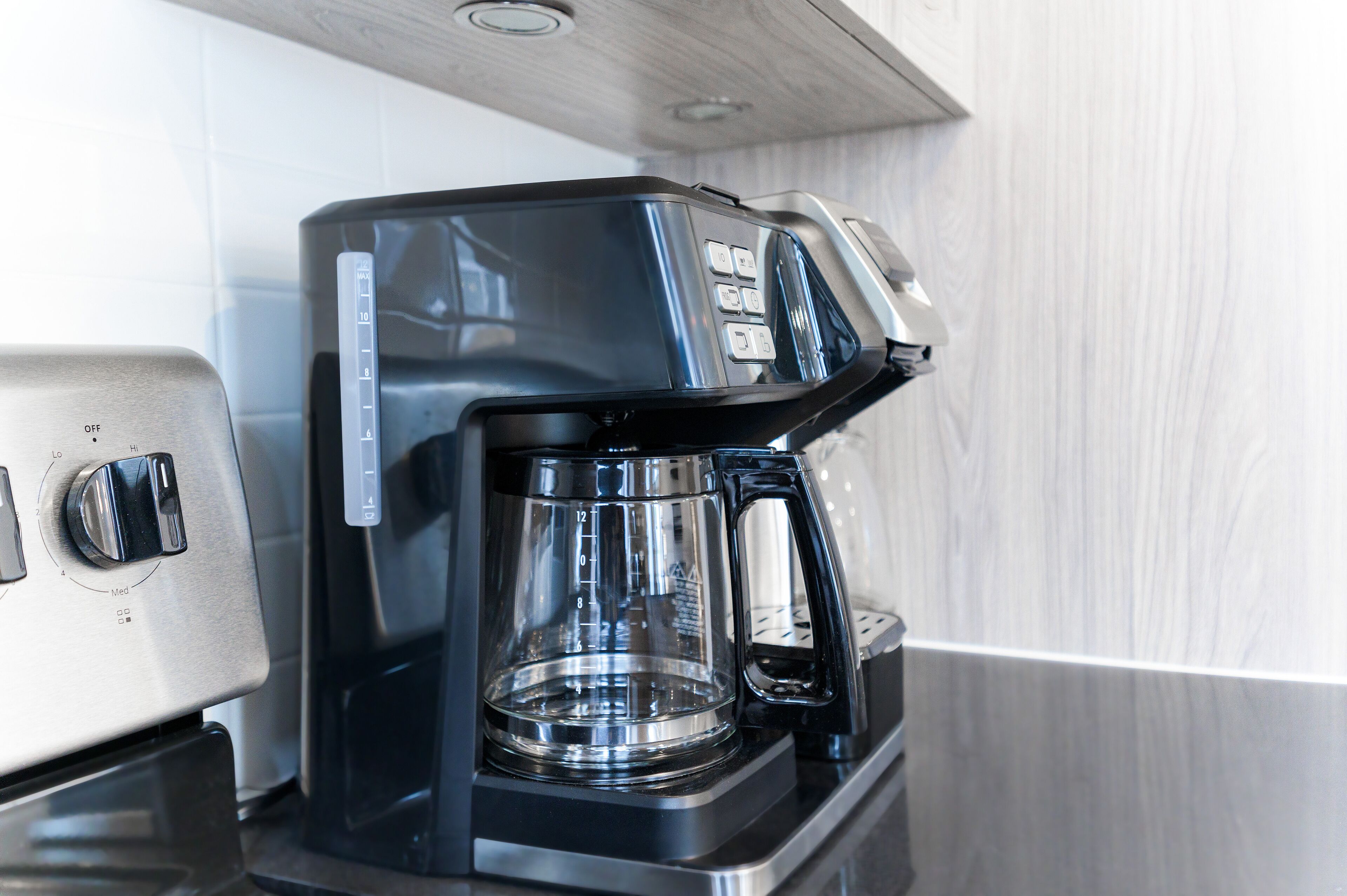 Una cafetera con jarra de vidrio transparente y pantalla digital.