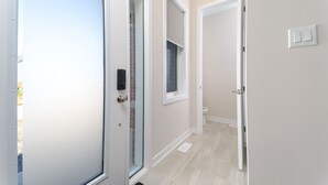 A hallway with a glass door, a window, and a light switch on the wall. - TownHome In Ottawa! (Ottawa)