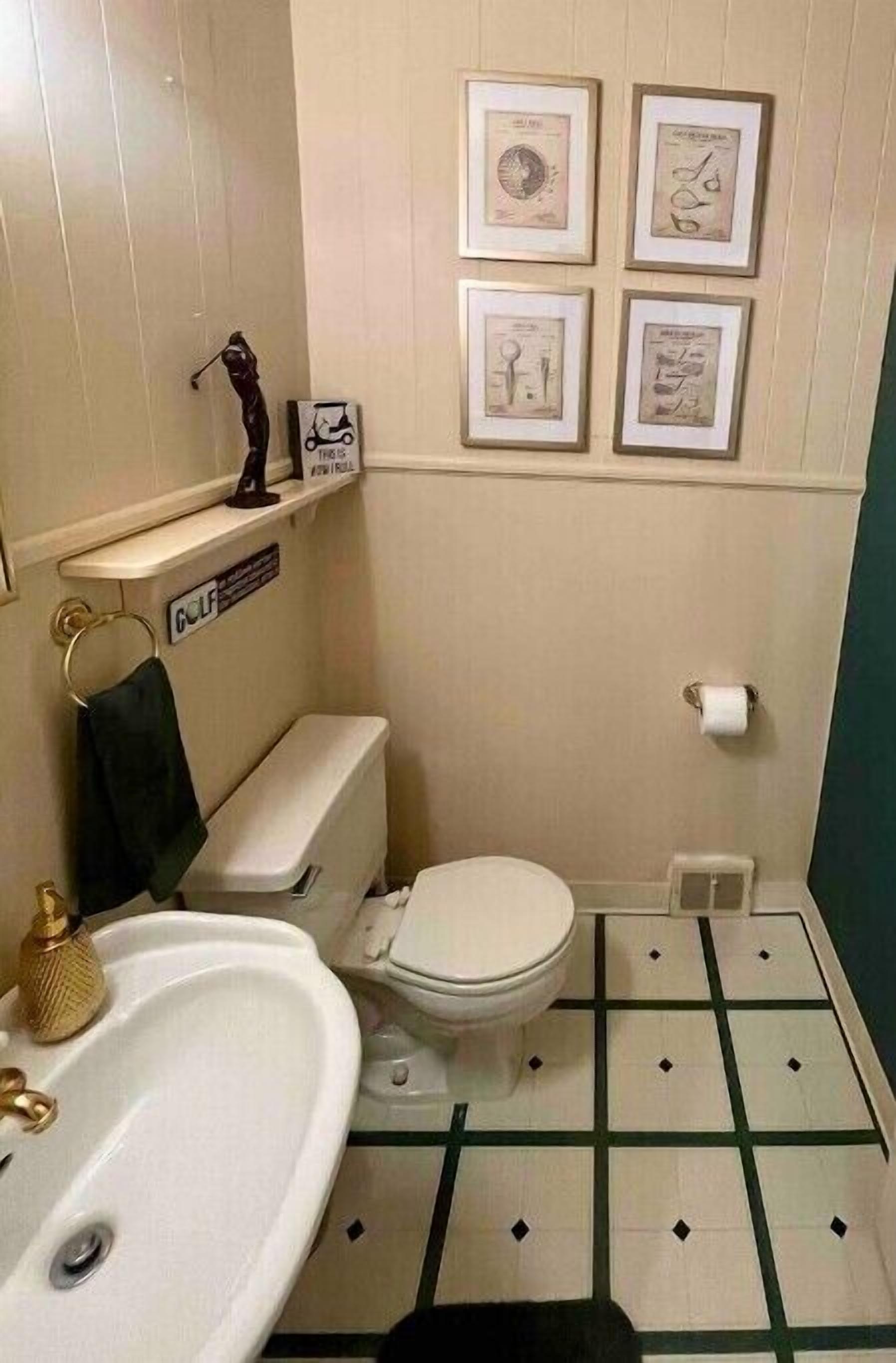 Une petite salle de bain avec des toilettes, un lavabo et des tableaux encadrés accrochés au mur.