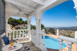 A covered outdoor area with a pool, white balustrades, and a view of the landscape. - Villa Mirador Mijas by Villa Plus (Valtocado)