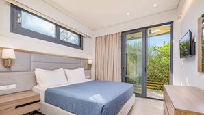 A modern bedroom with a bed, bedside tables, a TV, and a sliding glass door to a balcony. - Villa Oras Corfu Dionisos by Villa Plus (Ionian Islands)