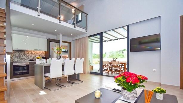 Een modern appartement met keuken, eetgedeelte en een balkon met televisie.