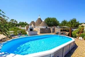 A swimming pool with a stone house in the background. - Villa Trullo Selva Grande by Villa Plus (Martina Franca)