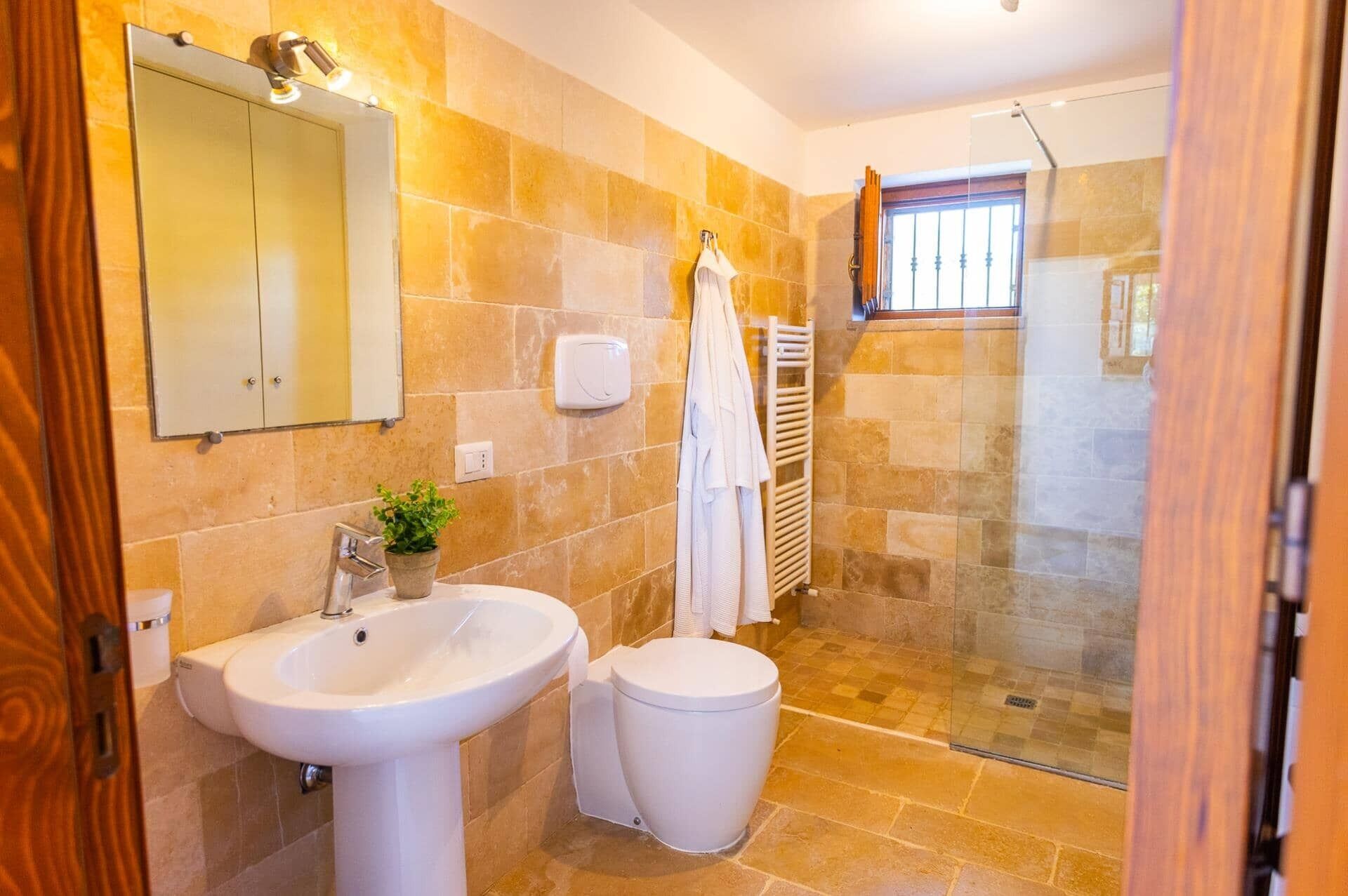A bathroom with a sink, toilet, and a glass shower enclosure.