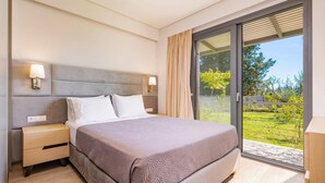 Ein modernes Schlafzimmer mit einem großen Bett, Nachttischlampen und Blick auf einen Garten durch eine Schiebetür.