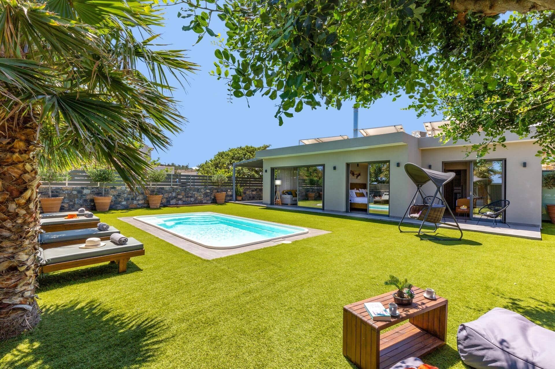A modern house with a swimming pool, a covered patio, and a well-maintained lawn.