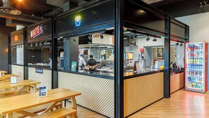 A fast-food restaurant with a counter, seating area, and a beverage dispenser. - UCD Campus Accommodation (Dublin)
