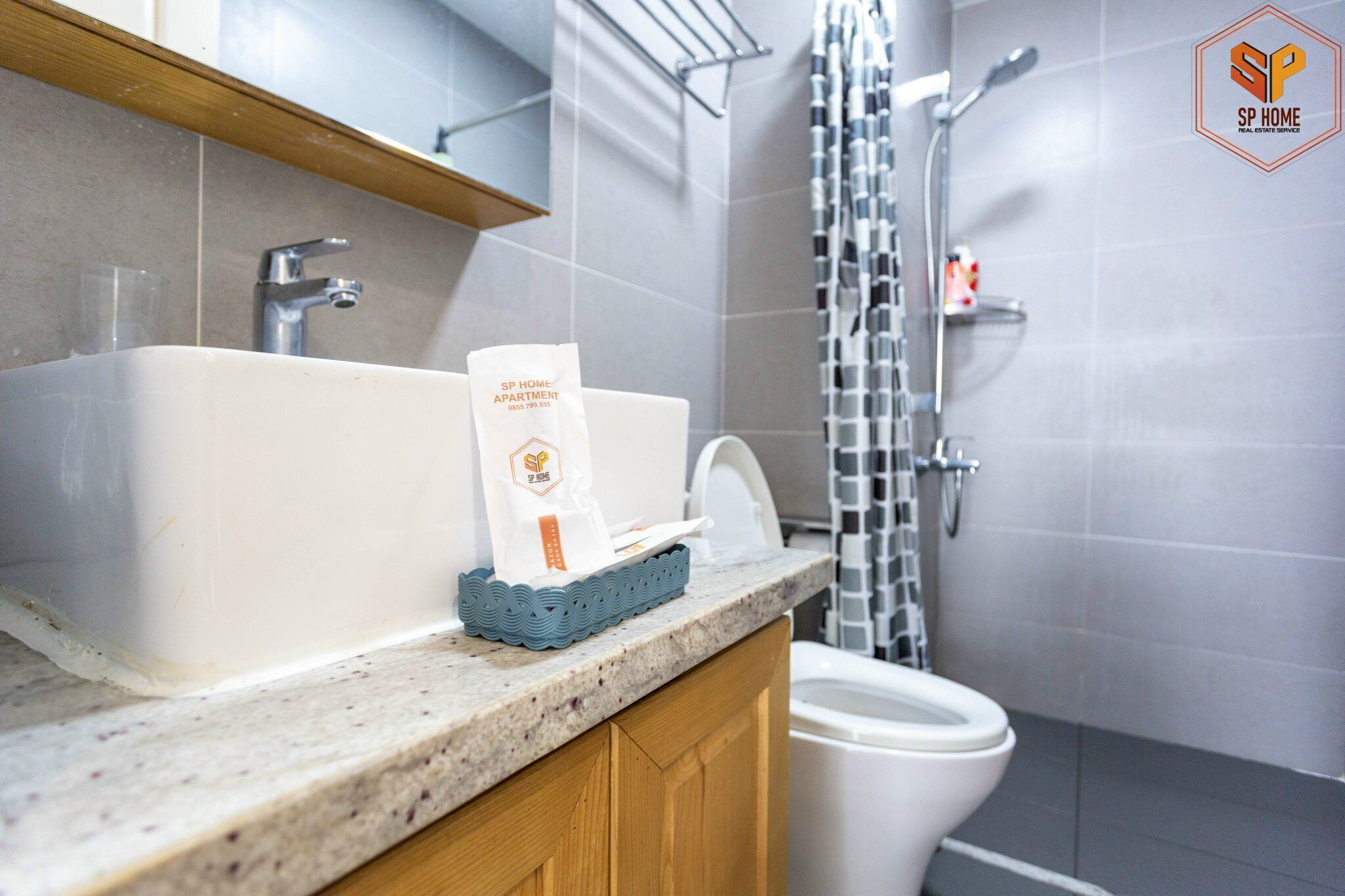 A bathroom with a white sink, a toilet, and a shower area.