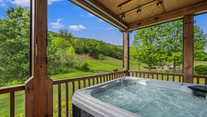 Un bain à remous sur une terrasse en bois, avec vue sur un paysage verdoyant.