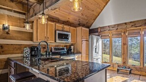 Une cuisine dotée de meubles en bois, de plans de travail en granit et d’appareils électroménagers modernes.