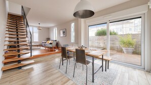A modern interior with a staircase, dining area, and large sliding glass doors to a backyard. - 300m from the beach, house for 7 with a pool (Lanton)