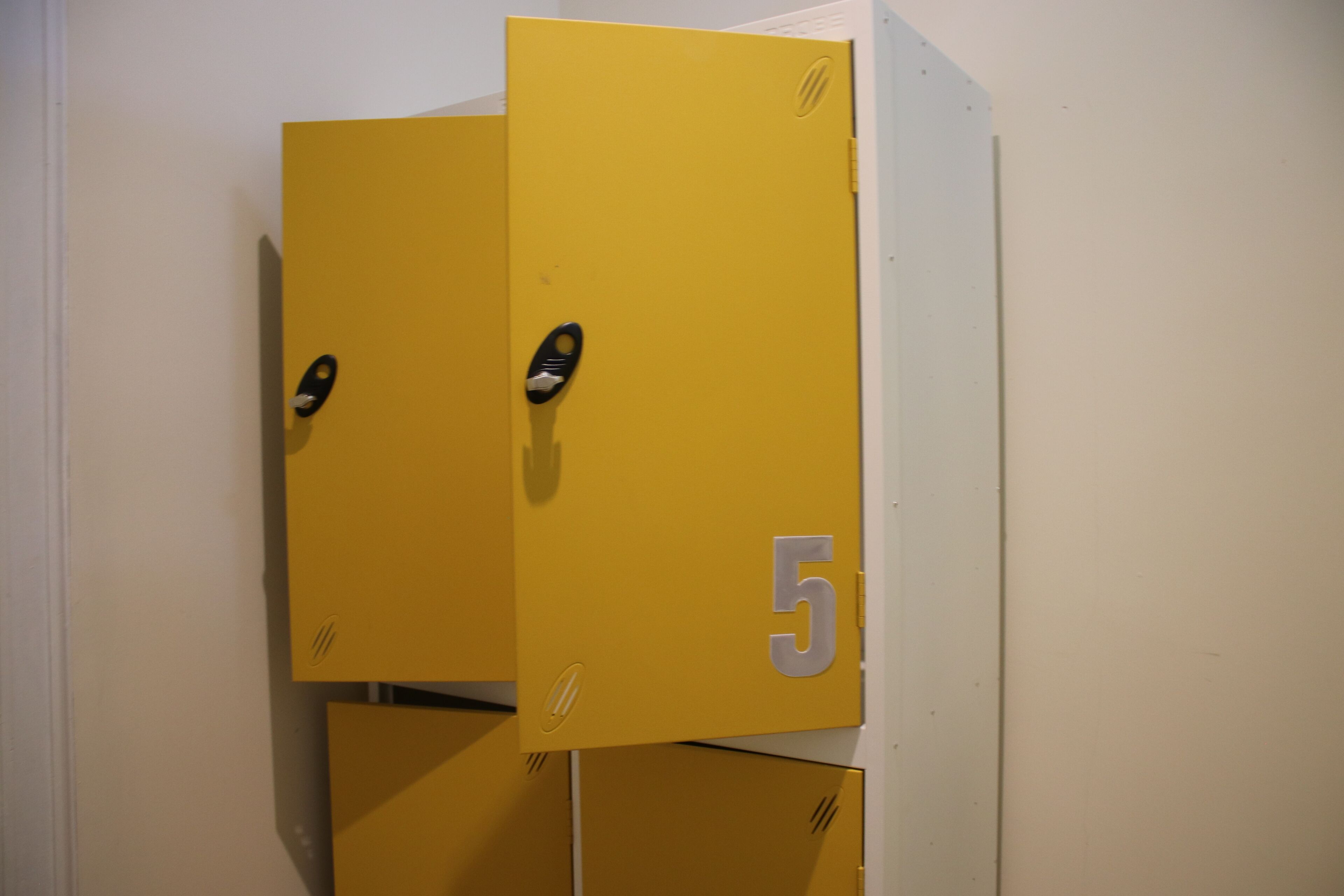 A set of yellow lockers with a number '5' on one of them.