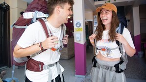 Two people with backpacks in a building with a staircase and a hand sanitizer dispenser. - Safestay Edinburgh Cowgate (Edinburgh)