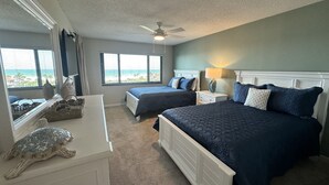 A bedroom with two beds, a ceiling fan, a dresser, and a window with a view. - Cathedral ceilings and incredible views in this 2Bed/2Bath Condo (Sarasota)