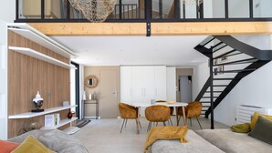 Ein modernes Wohnzimmer mit einer Couch, einem Couchtisch und einem Essbereich mit Stühlen und einem Tisch.
