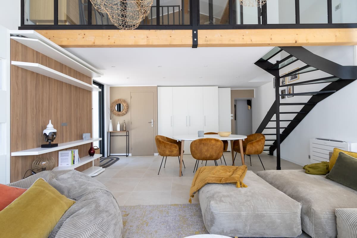 Una sala moderna con un sofá, una mesa de centro y un comedor con sillas y una mesa.