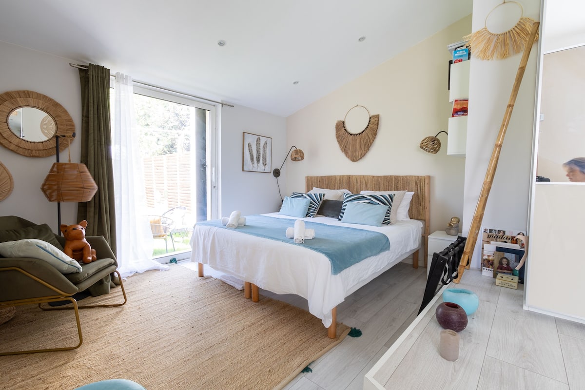 Un dormitorio con cama, sofá, un ventanal y vistas al exterior.
