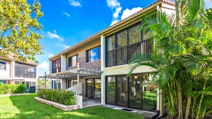 A modern two-story house with a covered patio, large windows, and a well-maintained lawn. - Bright and Peaceful garden view 2 Bed/ 2 Bath (Sarasota)