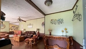 Una sala de estar con un sofá de cuero marrón, una mesa de centro de madera y una consola decorativa.
