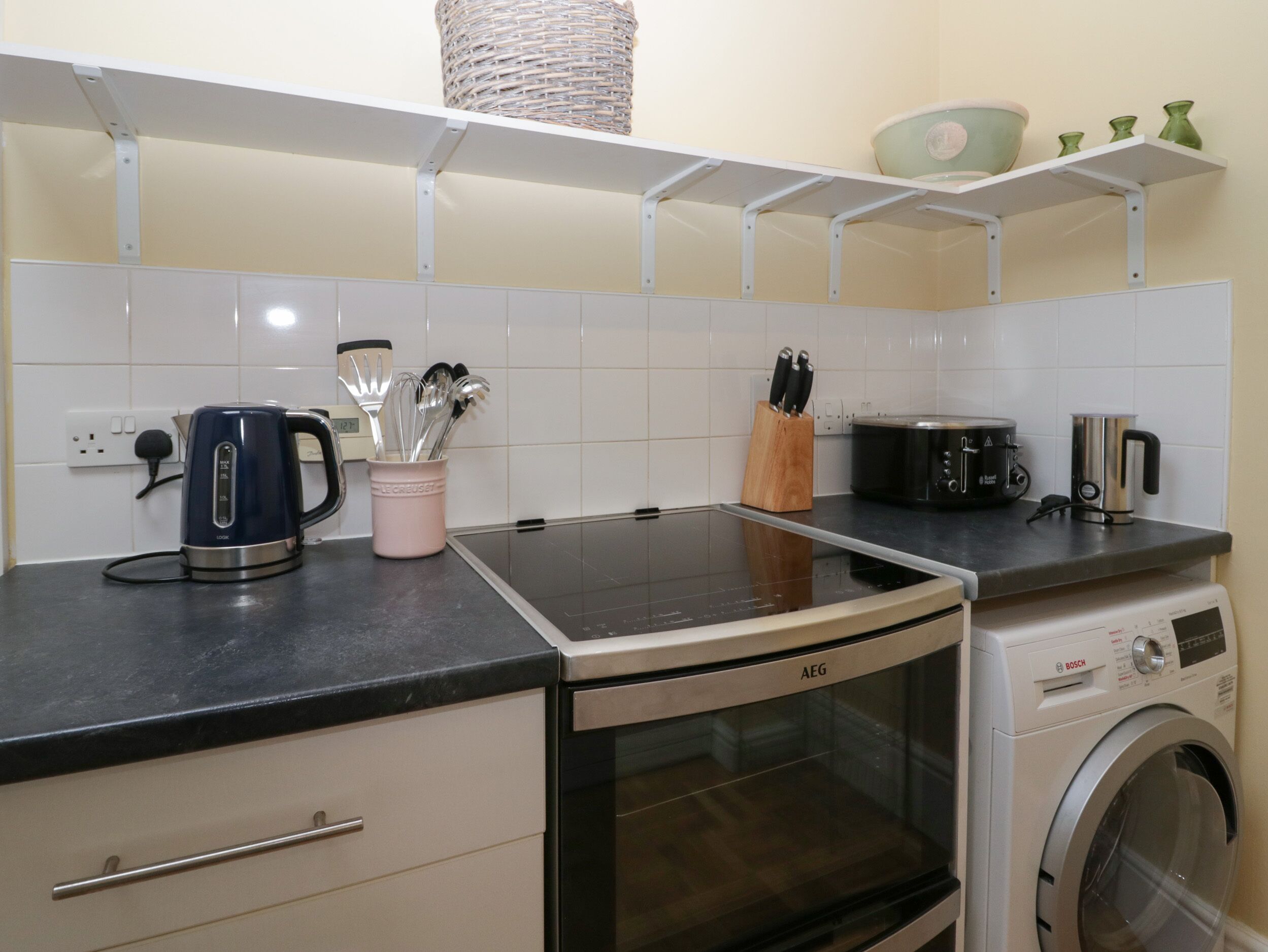 A kitchen with a stove, microwave, and washing machine.