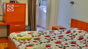 Une chambre d’hôtel avec un lit, un bureau, une armoire et une vue sur l’extérieur.