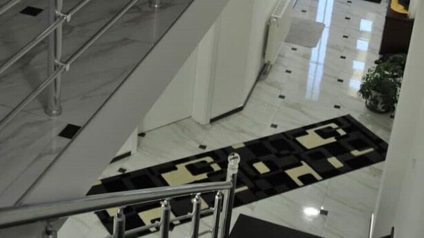 Un intérieur à plusieurs niveaux, avec un escalier, un sol carrelé et une cuisine ouverte.