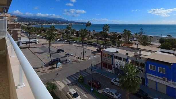 Un paisaje costero con vistas al mar, palmeras y edificios.