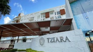 A modern building with a sign reading "TZIARA" and a covered entrance area. - Sky Condo Tziara Panoramic View 8 Minutes From the Beach (Cancún)