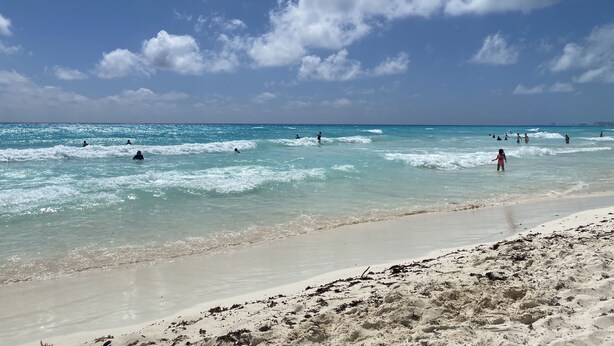 A beach with clear turquoise waters and a sandy shore. - Sky Condo Tziara Panoramic View 8 Minutes From the Beach (Cancún)