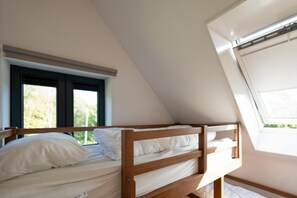 Relax in this loft-style room with a comfortable bed under a window.