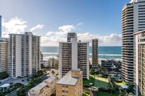 Un hôtel de grande hauteur doté de nombreux balcons donnant sur une plage.