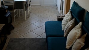 Une pièce comprenant une table à manger, des chaises, un canapé et un radiateur.