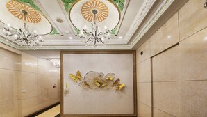 A hallway with a decorative wall, a chandelier, and a framed artwork. - I need motel (Xinfeng)
