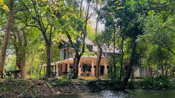A house surrounded by trees and a body of water. - Sigiri Vananthara  (Habarana)