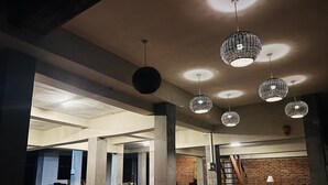 A modern interior with exposed brick walls, wooden furniture, and unique spherical pendant lights. - Sigiri Vananthara  (Habarana)
