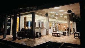 An interior space with a tiled floor, wooden furniture, and hanging spherical light fixtures. - Sigiri Vananthara  (Habarana)