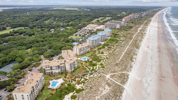 Un hôtel situé sur la côte, composé de plusieurs bâtiments, avec une plage et un parcours de golf.