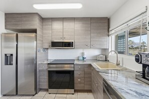 Eine moderne Küche mit Einbauofen, Mikrowelle und Edelstahl-Kühlschrank.