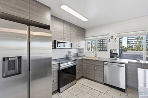 A modern kitchen with stainless steel appliances, a microwave, and a dishwasher. - Seaspray Condos - 100A (Fort Walton Beach)