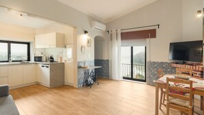 A modern apartment with a kitchen, dining area, and balcony. - Casa Curva do Rio (Melres)