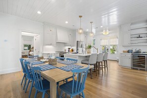 A spacious kitchen with white cabinetry, a central island, and pendant lighting.