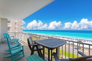 A balcony with a view of a beach and ocean.