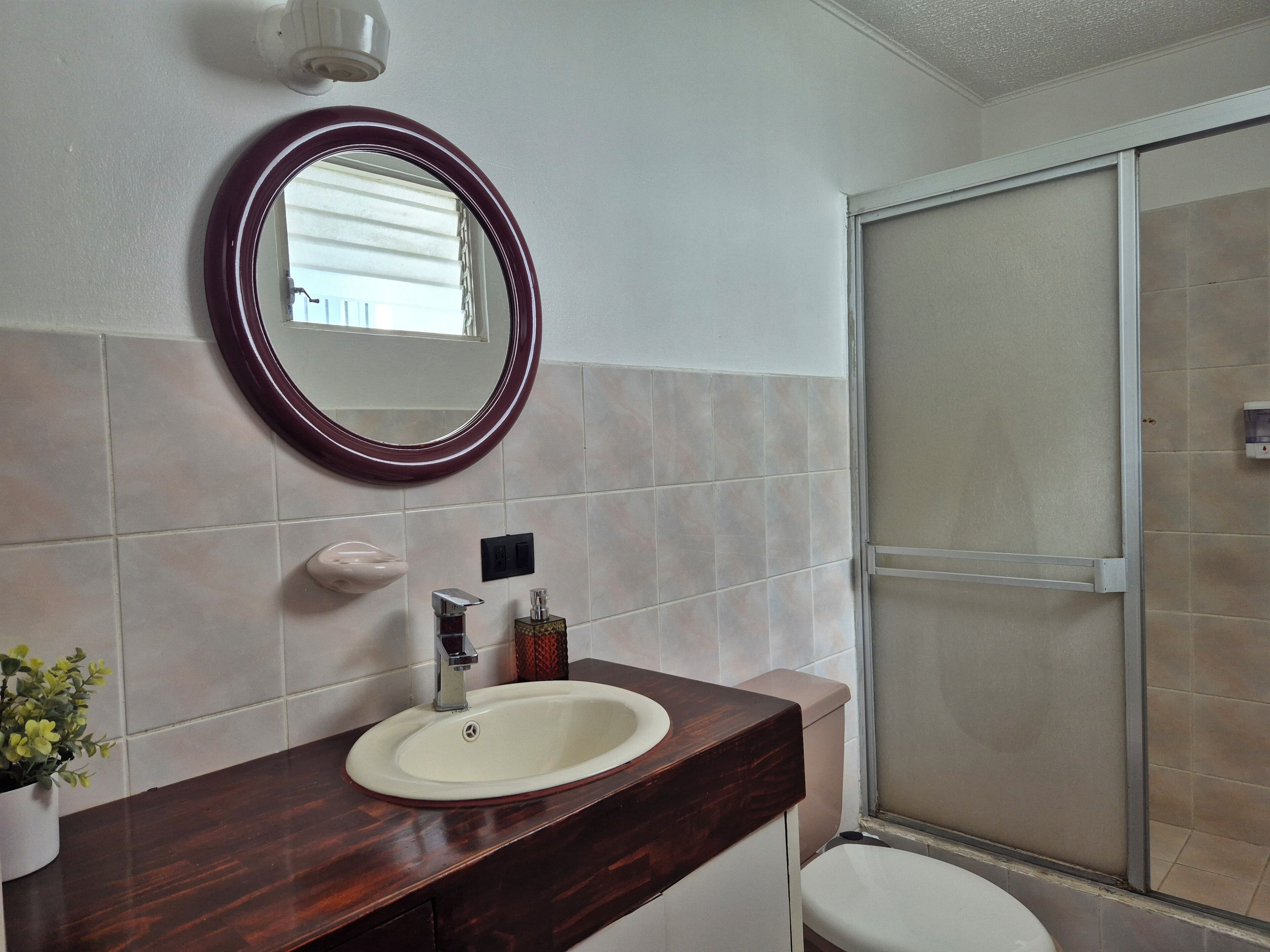 Ein Badezimmer mit Waschbecken, Spiegel und Dusche.